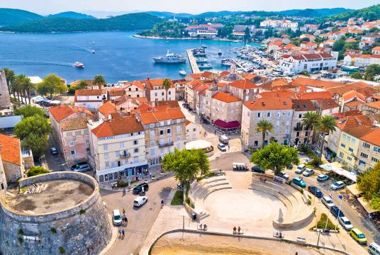A city with red roofs and a body of water