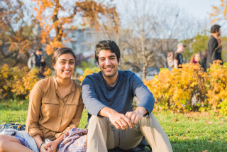 Students sitting together on lower field of campus