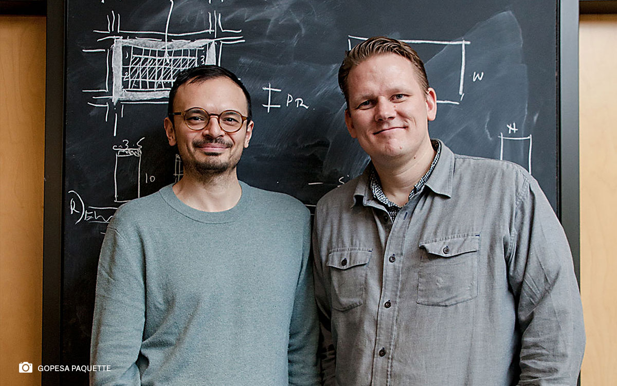 Professor Salmaan Craig and Professor Kiel Moe smiling in front of a blackboard