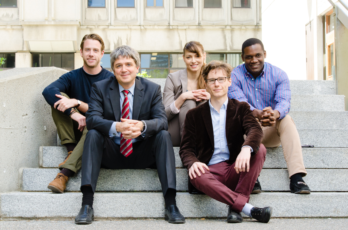 A group of researchers sit outside on the steps of a building on McGill's downtown campus