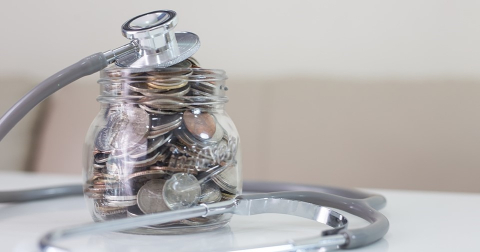 A jar full of coins and a stethoscope. 