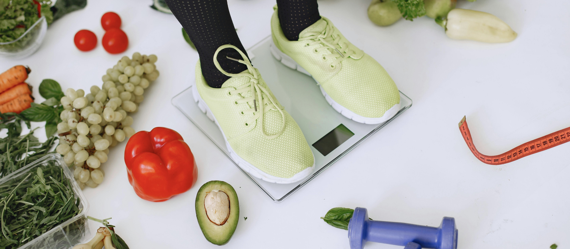 Yellow running shoes on scale surrounded by food and weights.