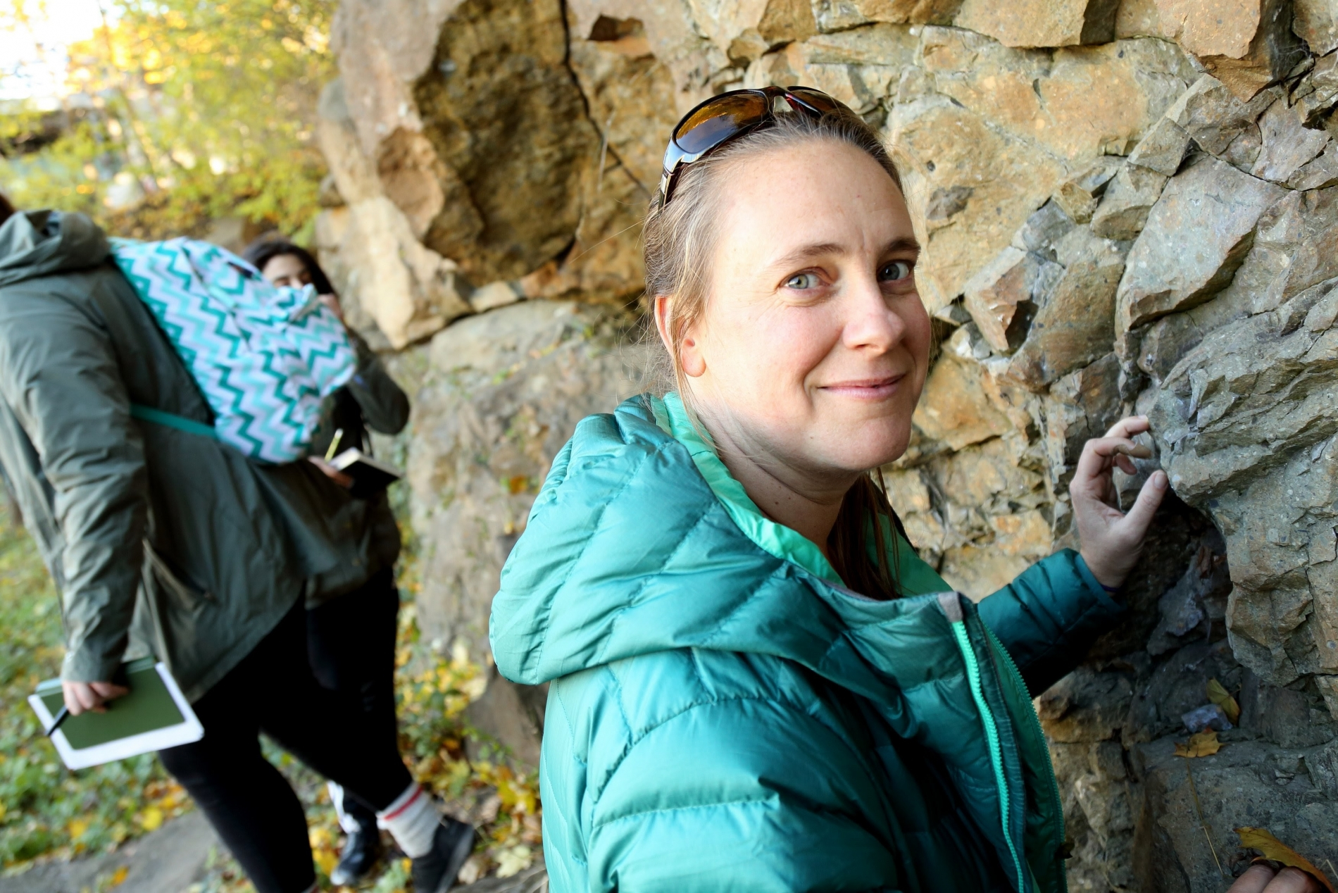 Professor Christie Rowe standing in front of rock wall